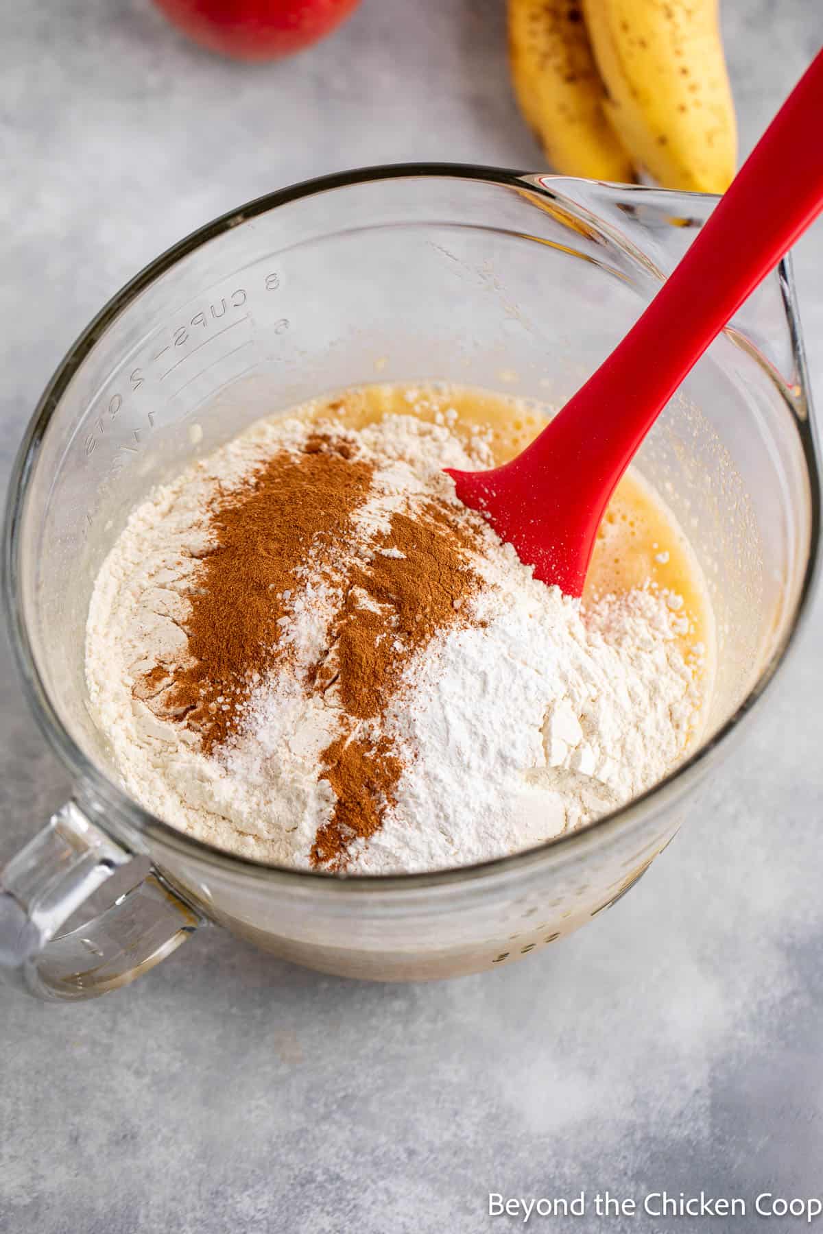 Adding flour and cinnamon to muffin batter. 