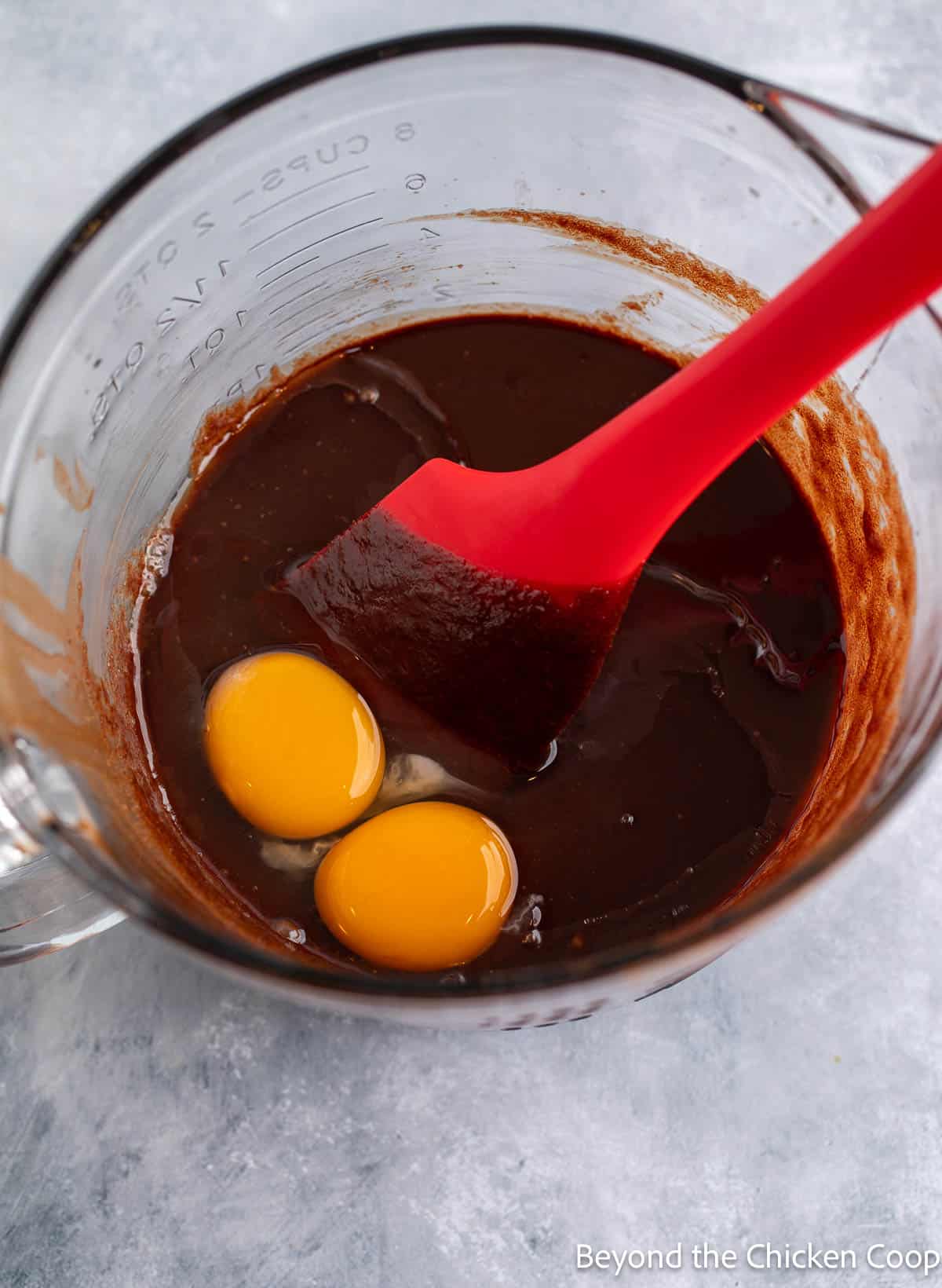 Mixing eggs into brownie batter.