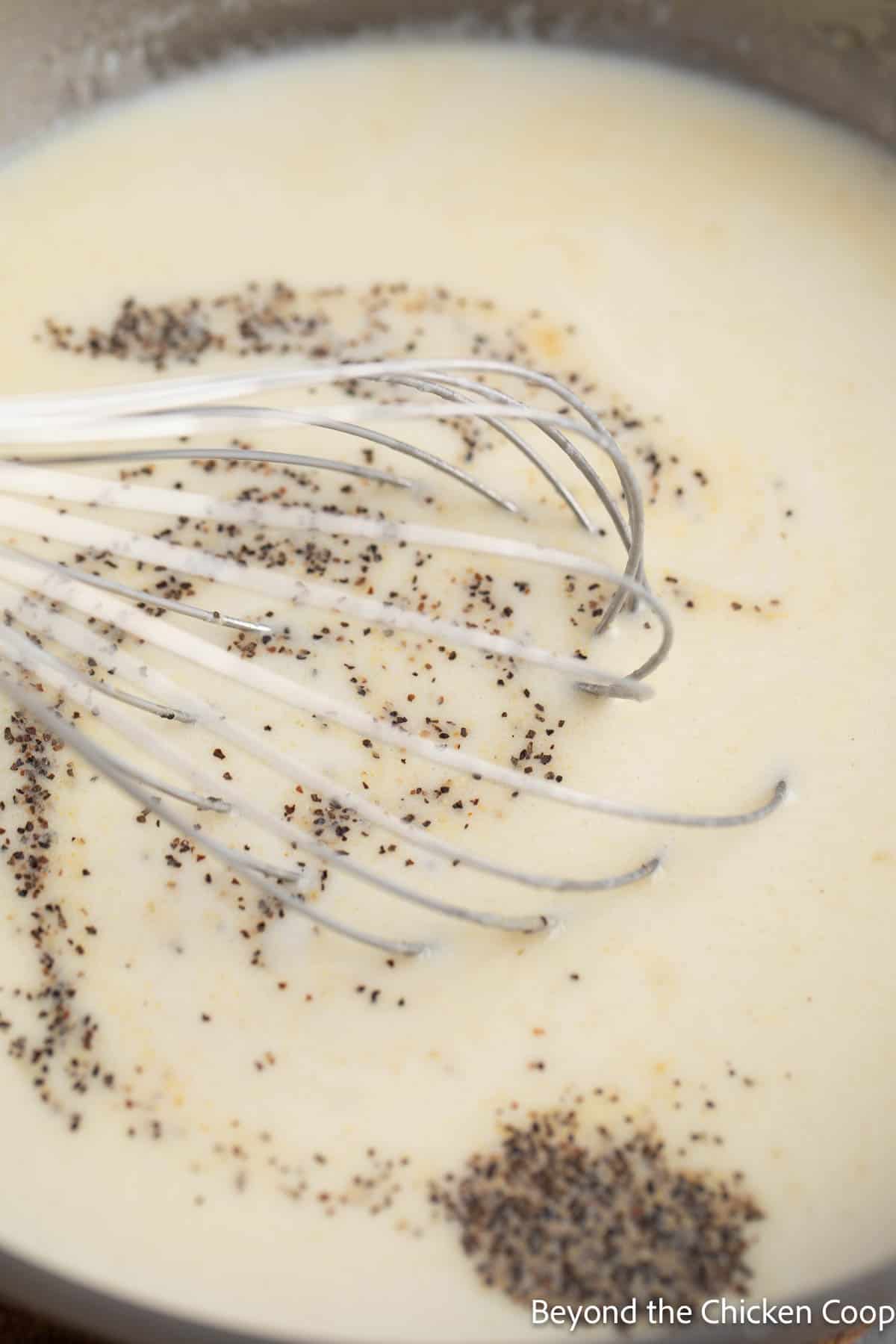 Stirring black pepper into white gravy. 