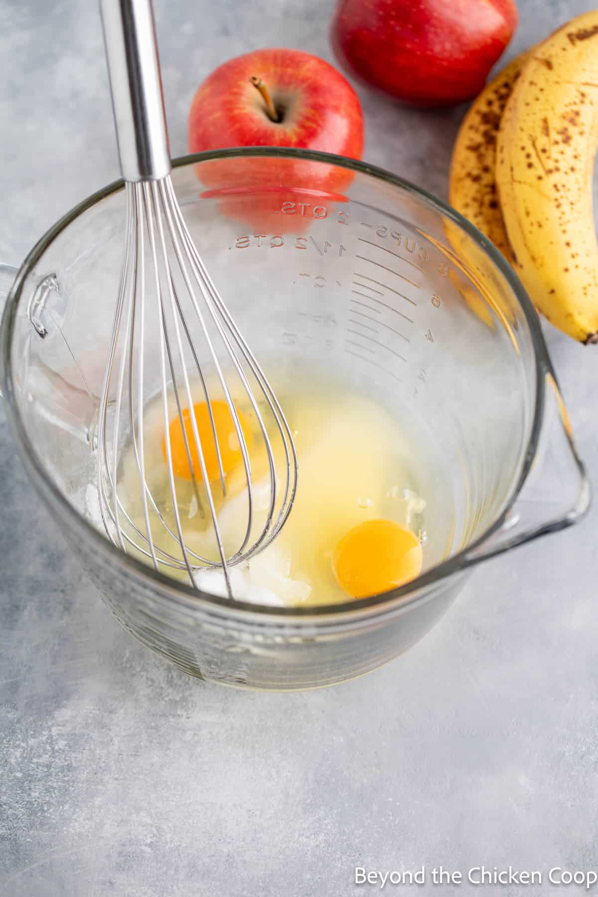Whisking sugar and eggs together in a glass bowl. 