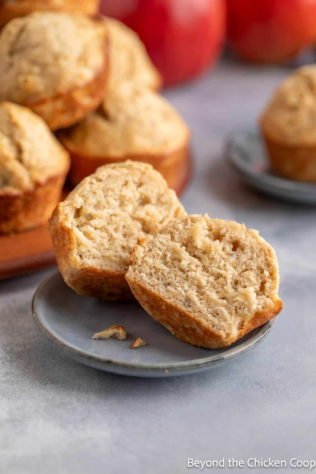 A muffin cut in half on a small plate. 