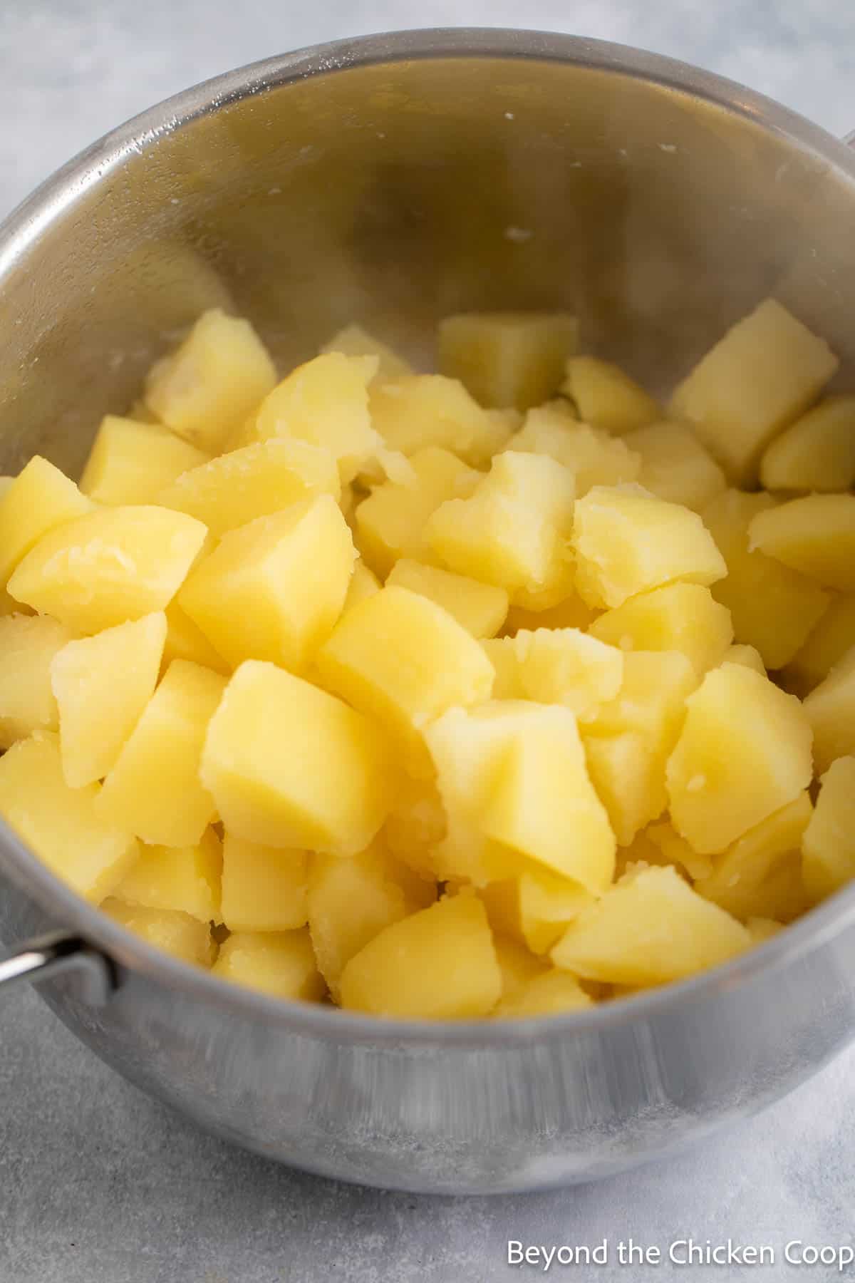 Cooked potato cubes in a pot. 