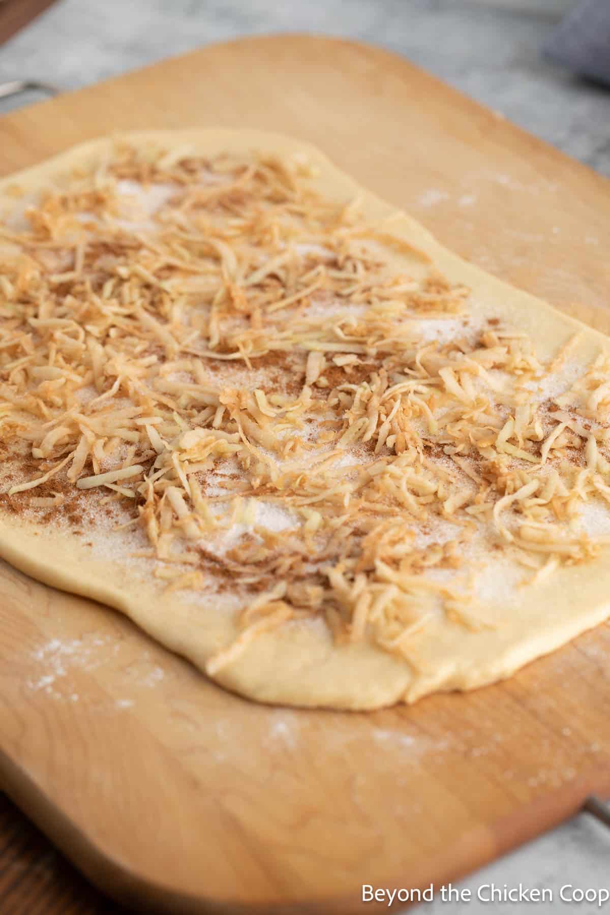 Rolled dough topped with cinnamon, sugar and grated apples. 
