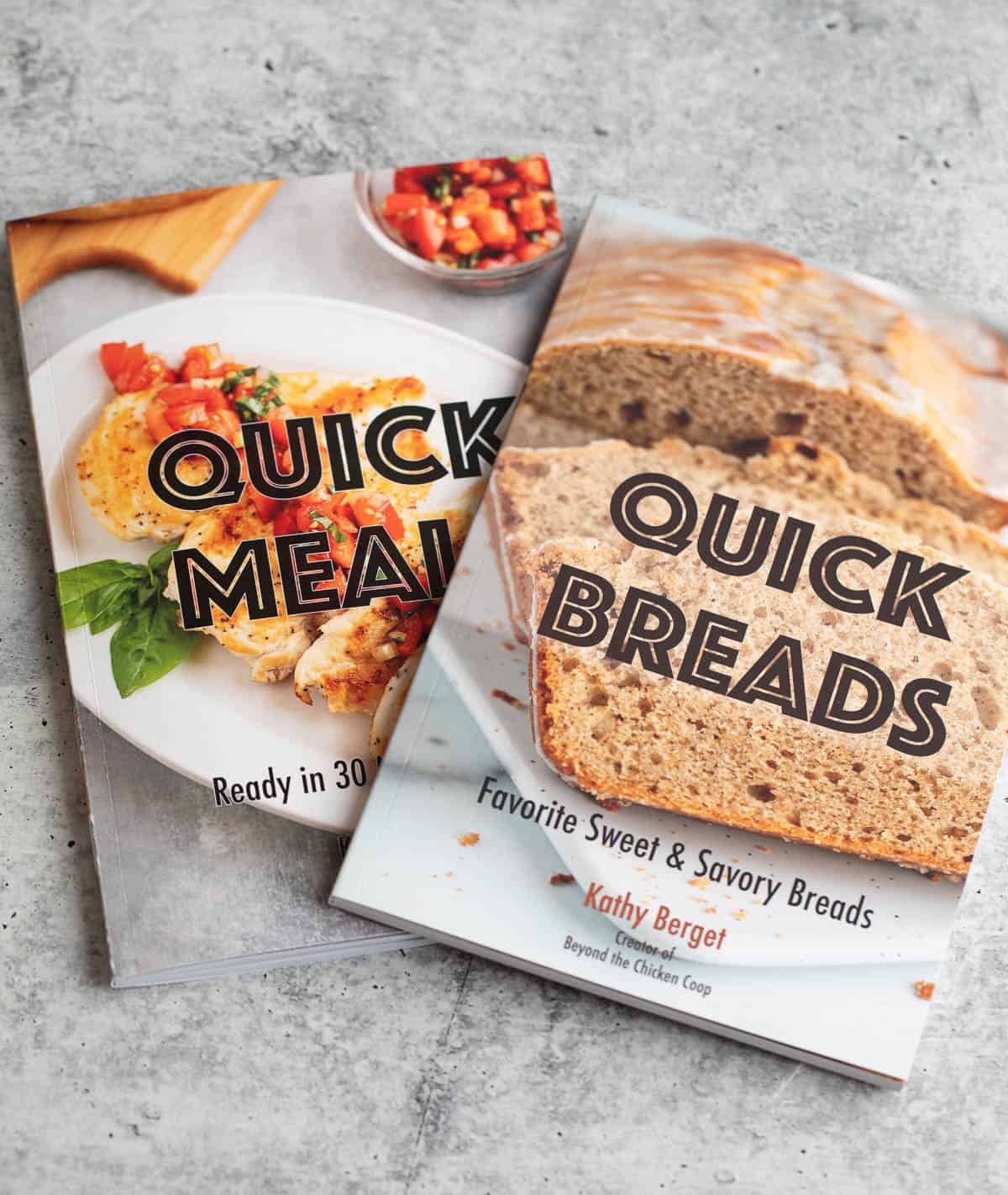 Two cookbooks piled on a counter.