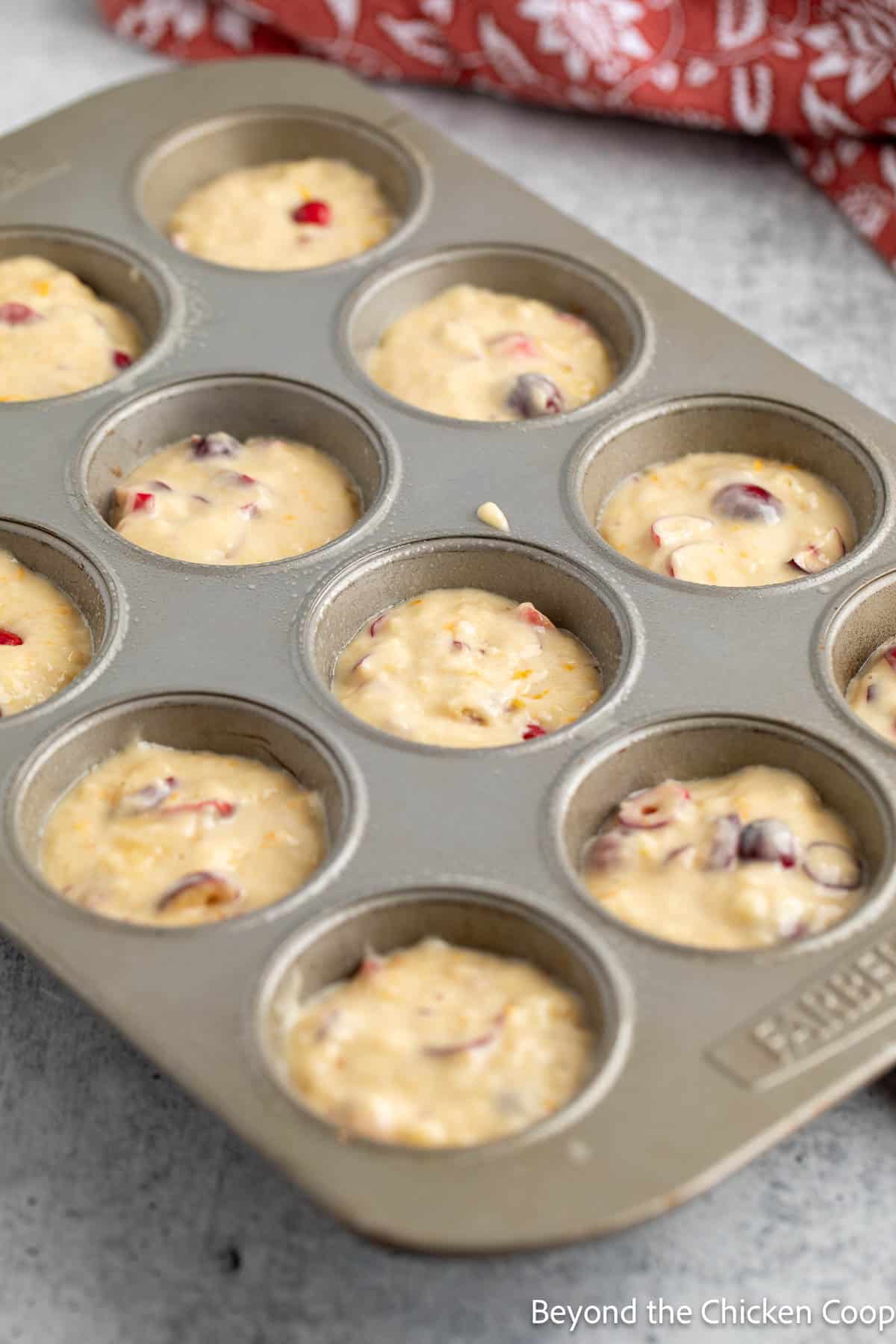 Muffin batter in a muffin tin. 