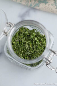 A small jar filled with dried oregano.