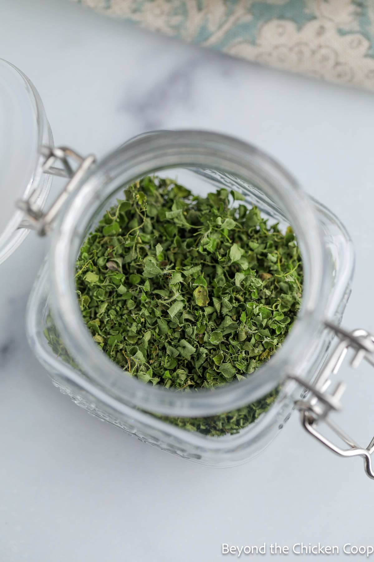 A small jar filled with dried oregano.