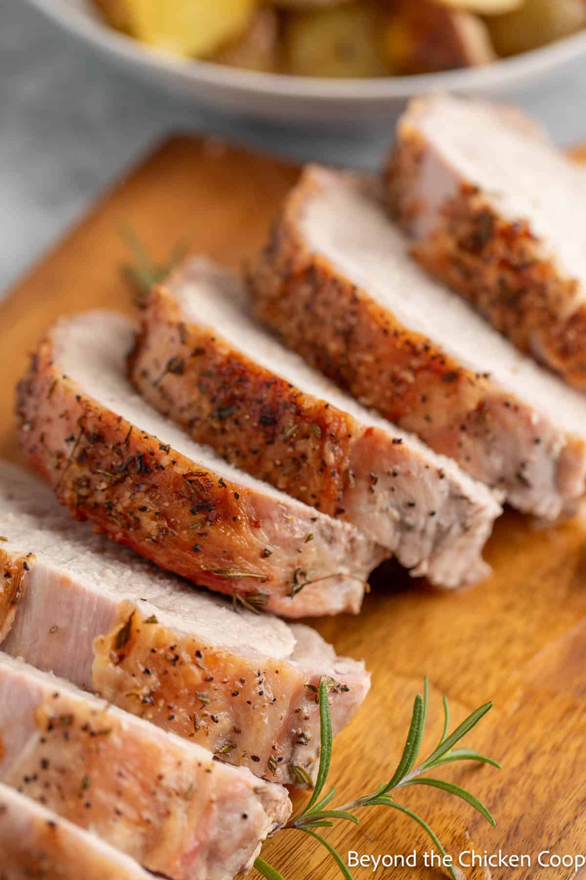 Sliced roasted pork on a wooden board.