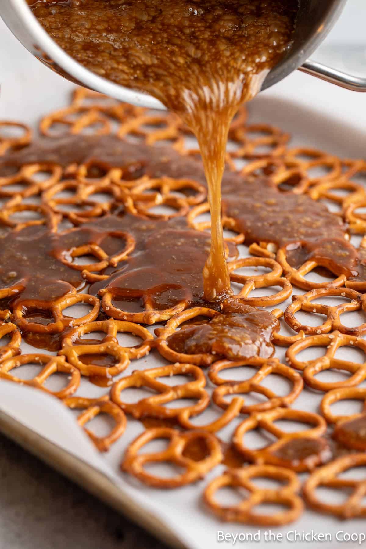 Pouring hot caramel sauce over pretzels. 