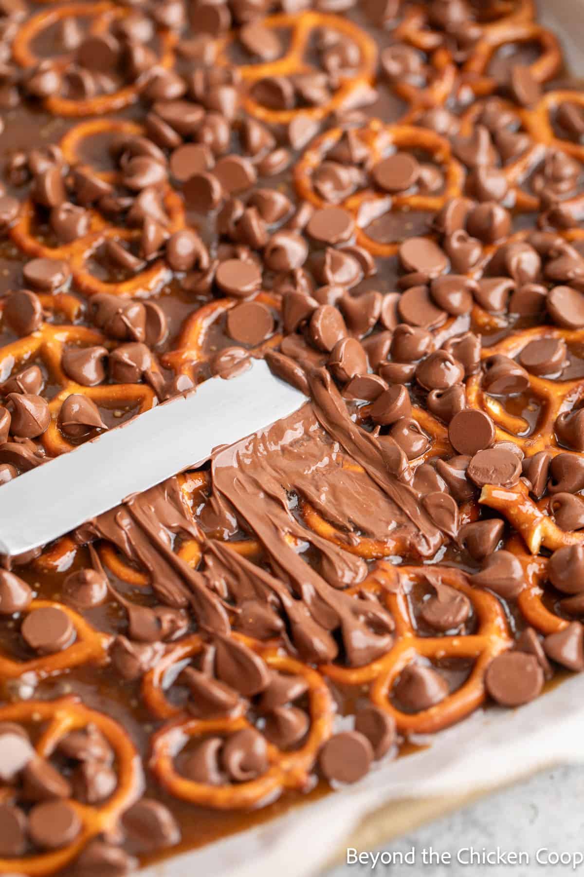 Spreading chocolate over pretzels. 