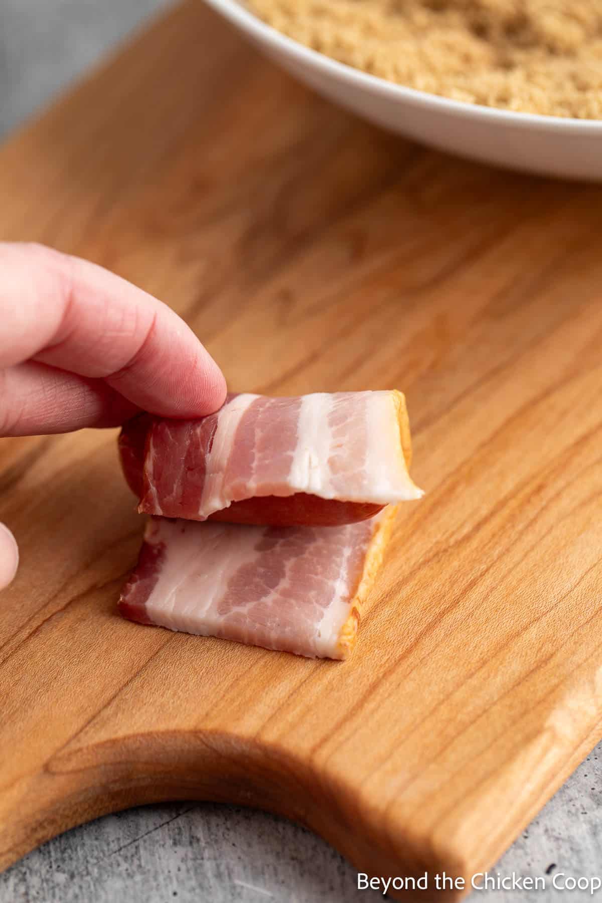 Wrapping a little smokie with a piece of bacon. 