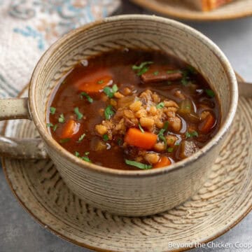 A mug filled with Beef and Barley Soup.