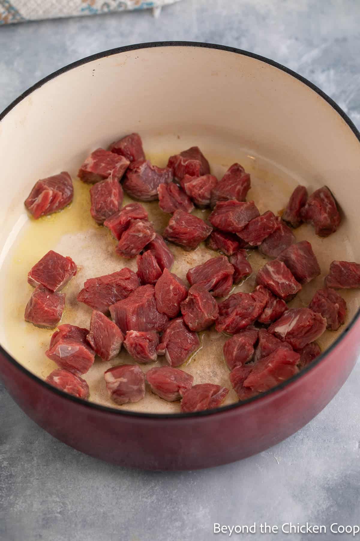 Braising chunks of beef in a dutch oven. 