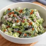 Easy broccoli salad with bacon bits in a white bowl.