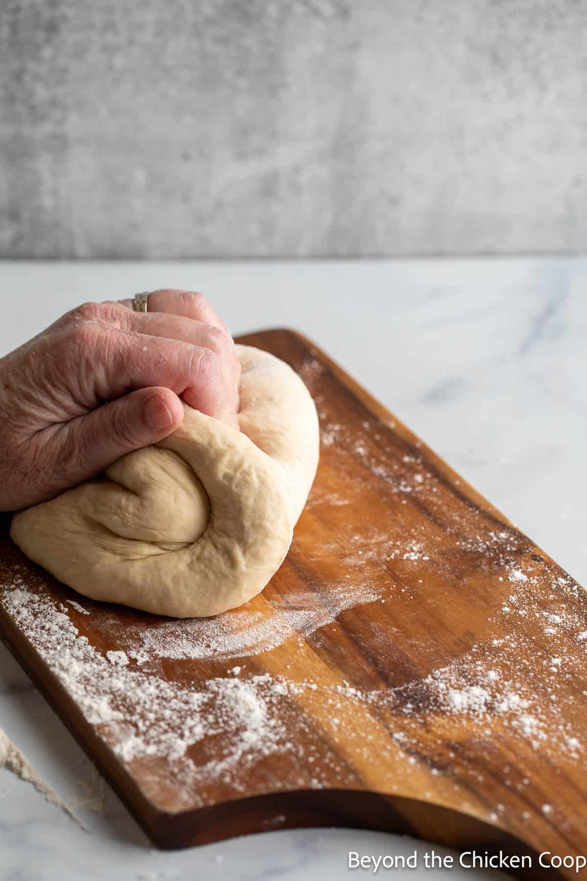Kneading bread dough on a board. 