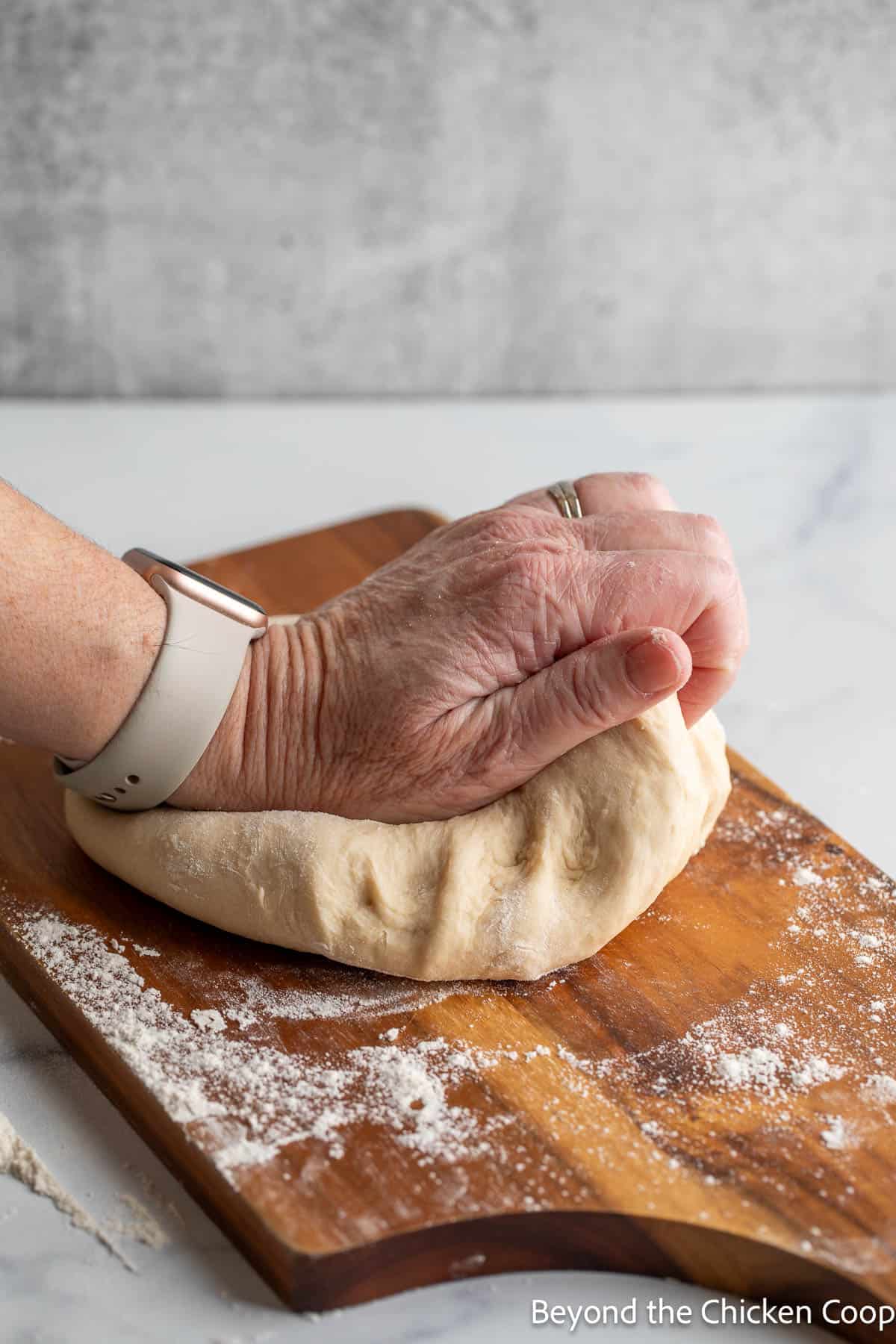 Kneading dough on a wooden board. 