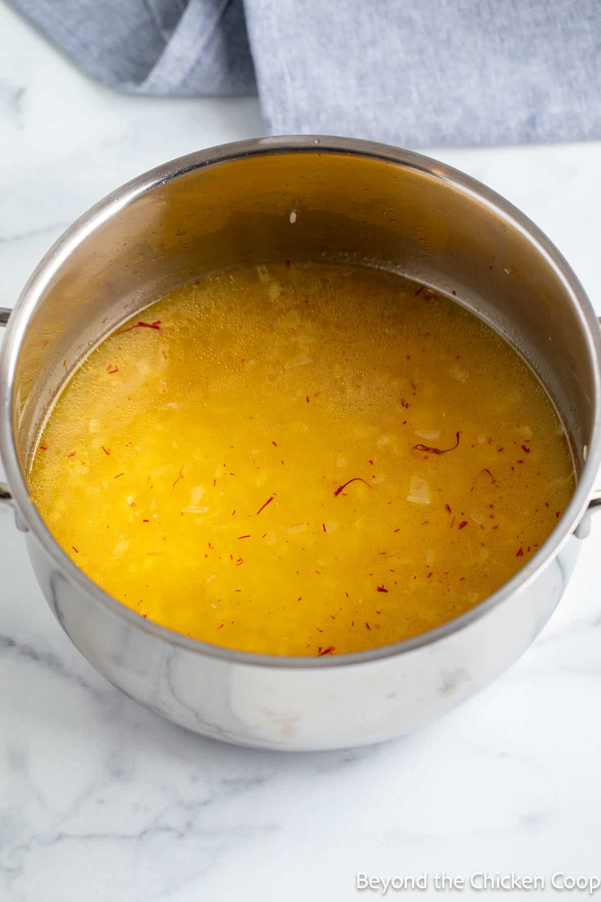 Chicken broth in a pot with rice.
