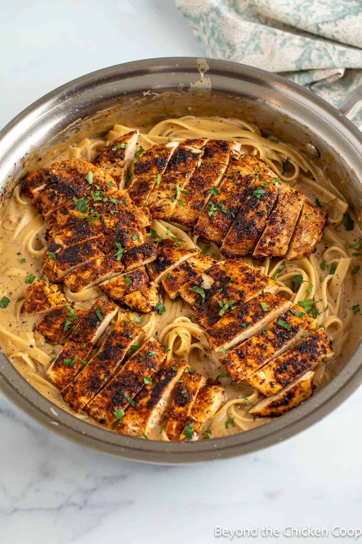 Seasoned chicken breast over pasta with alfredo sauce. 
