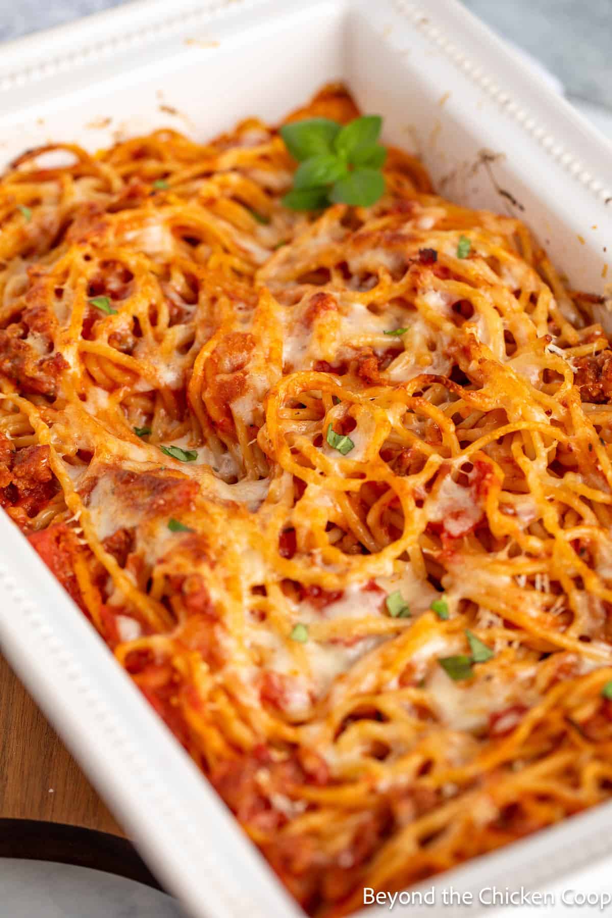 Baked spaghetti topped with freshly chopped parsley.