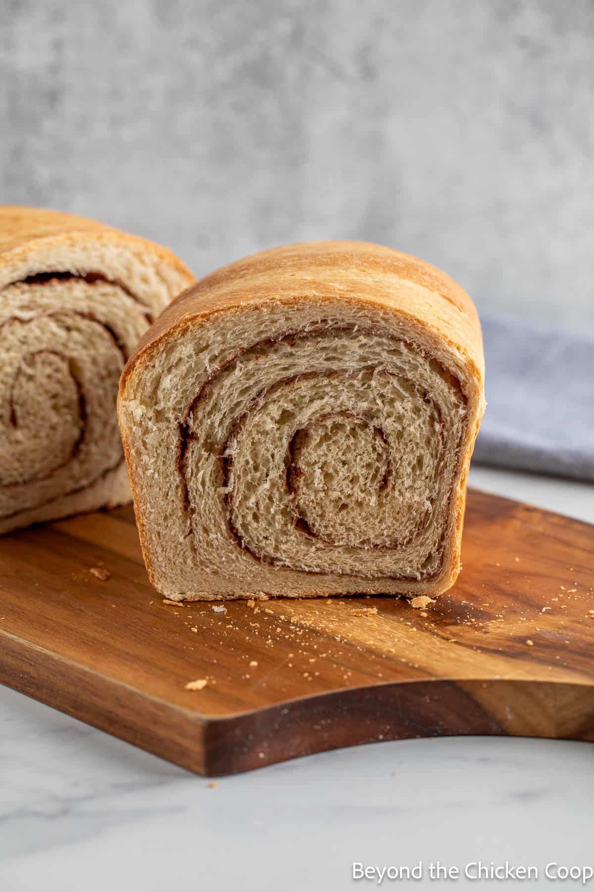 A loaf of bread with a swirl of cinnamon on a board. 