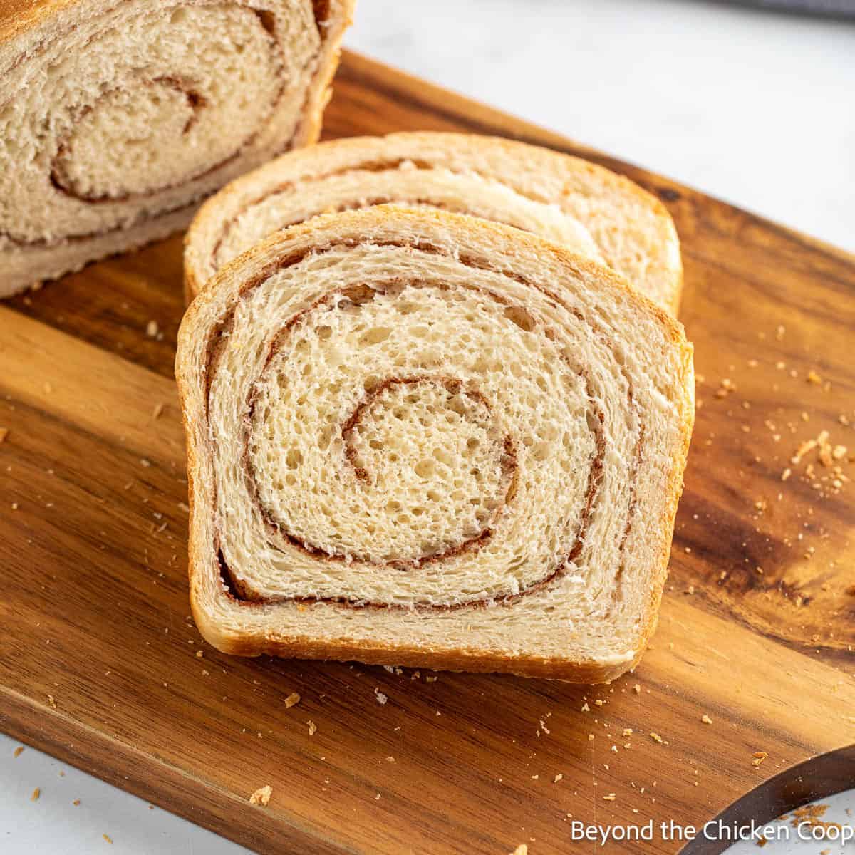 Slices of Cinnamon Swirl Bread on a wooden board. 