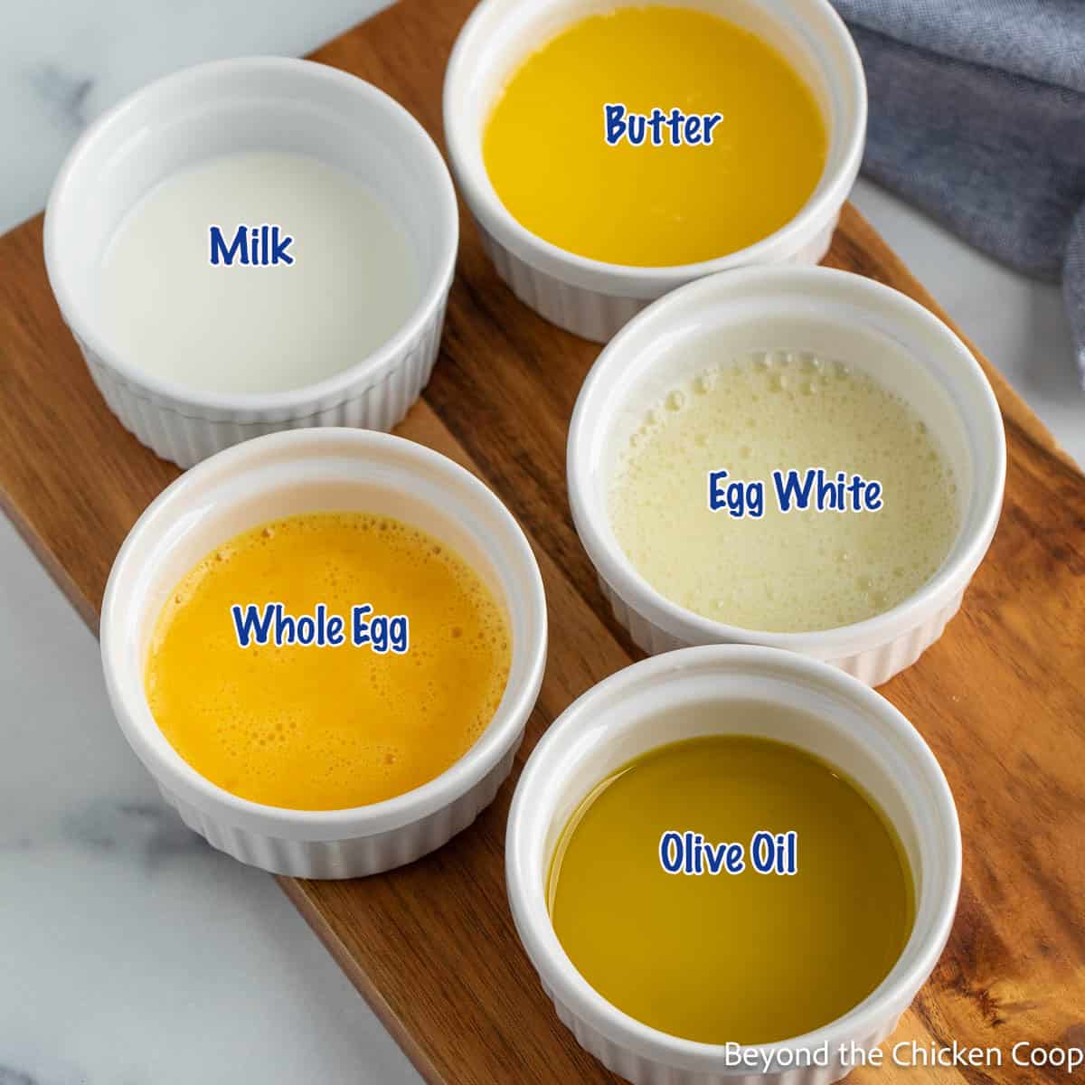 Small white bowls filled with different types of glazes for bread dough. 