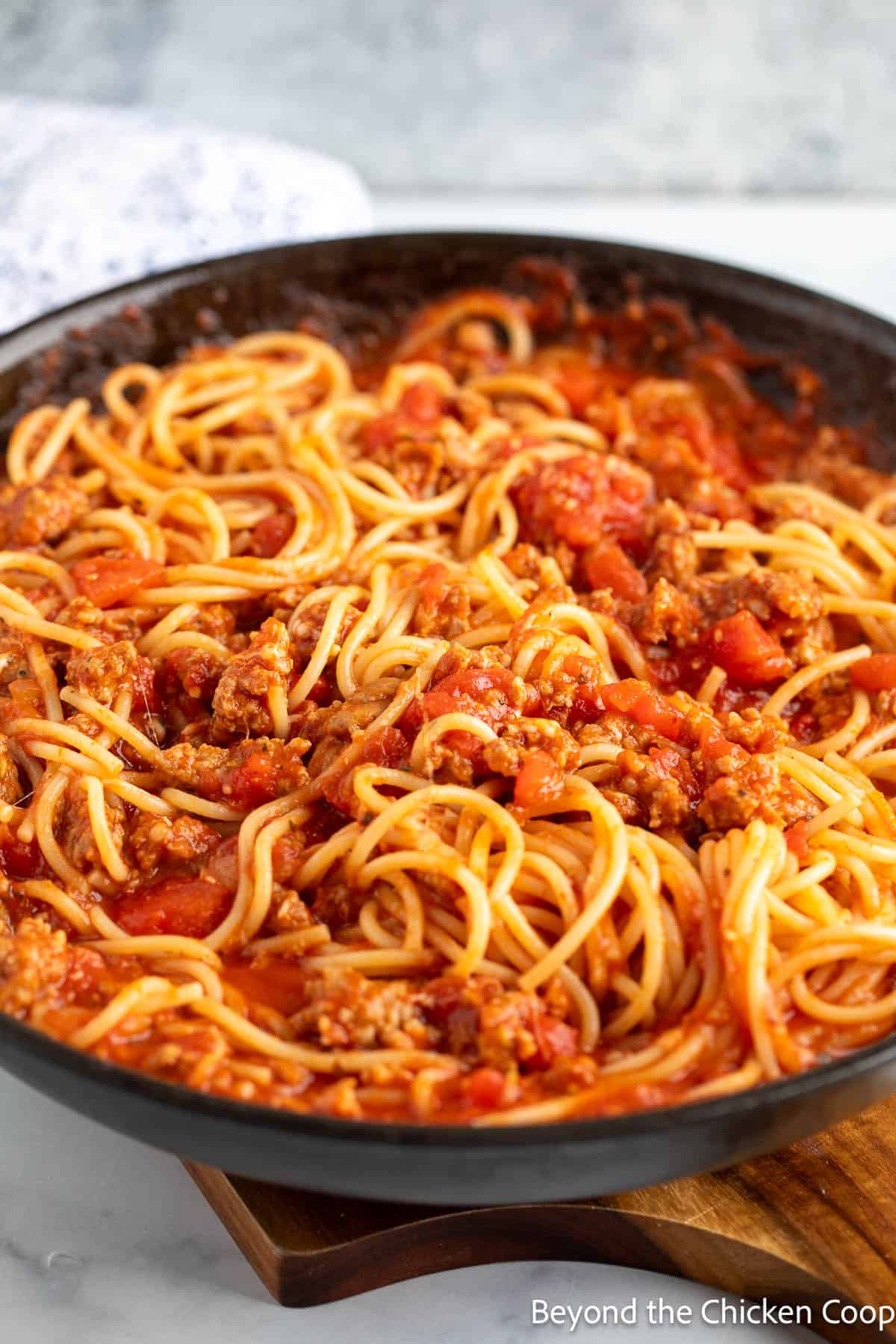 Spaghetti noodles with meat sauce in a pan. 