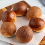 A circle of round dinner rolls each with a different finished glaze.