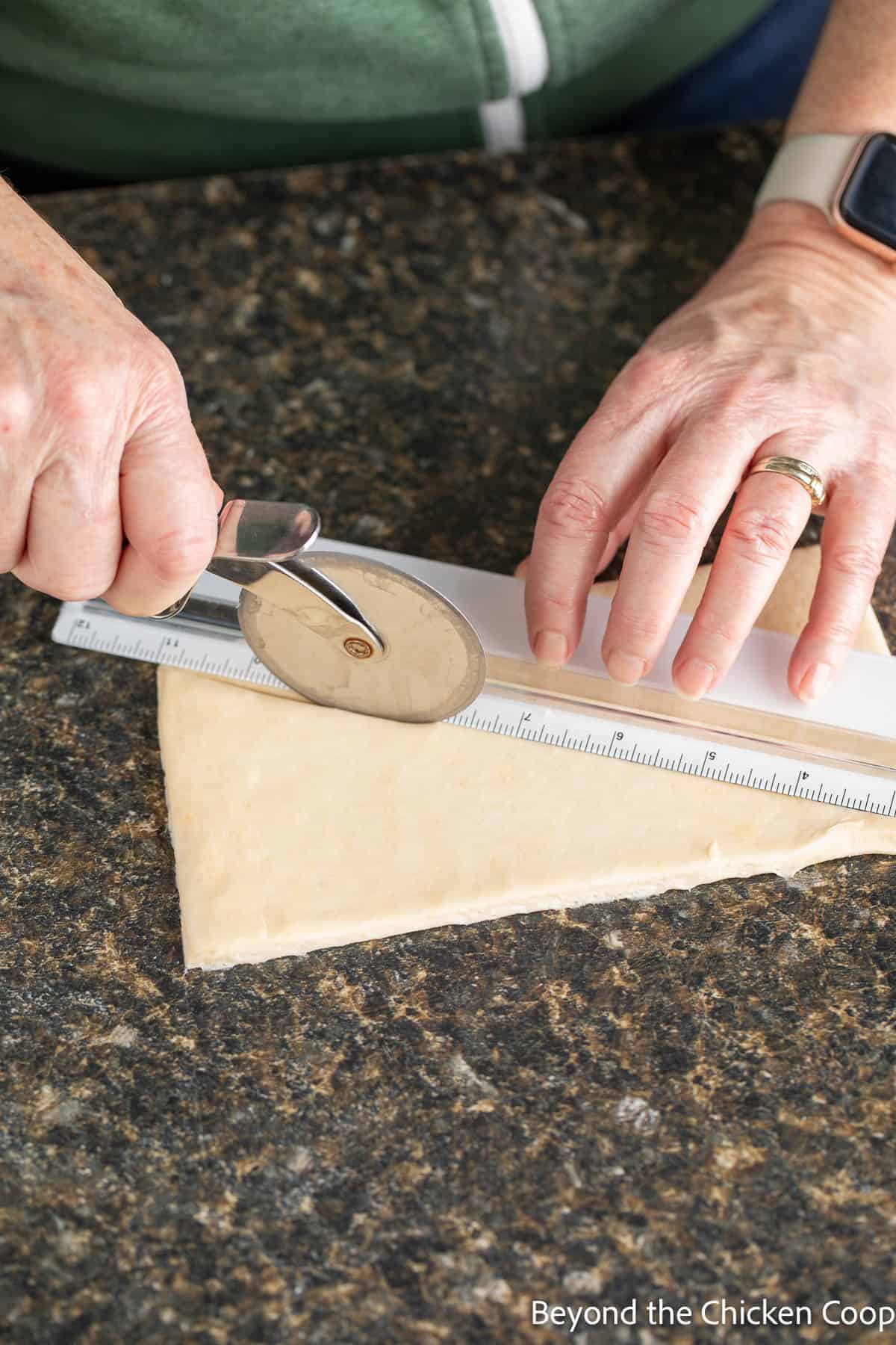 Cutting croissant wedges with a pizza cutter. 