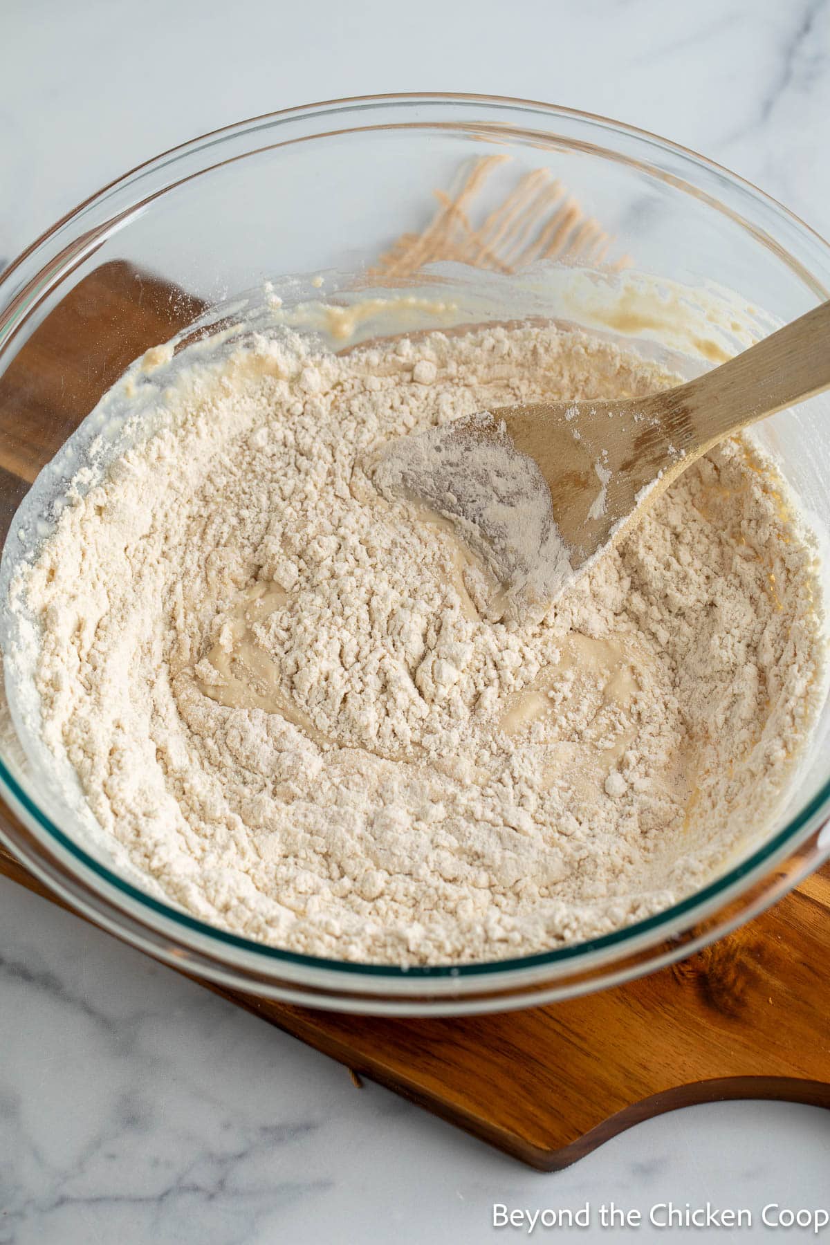 Stirring flour into milk in a glass bowl. 
