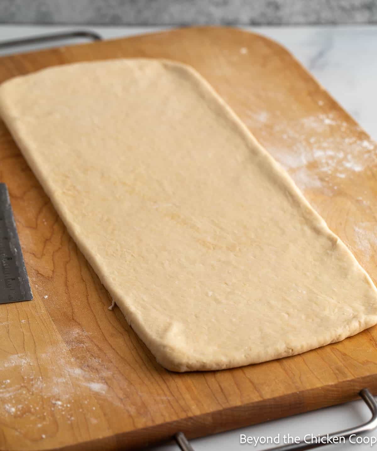 Rolling out dough on a wooden board. 