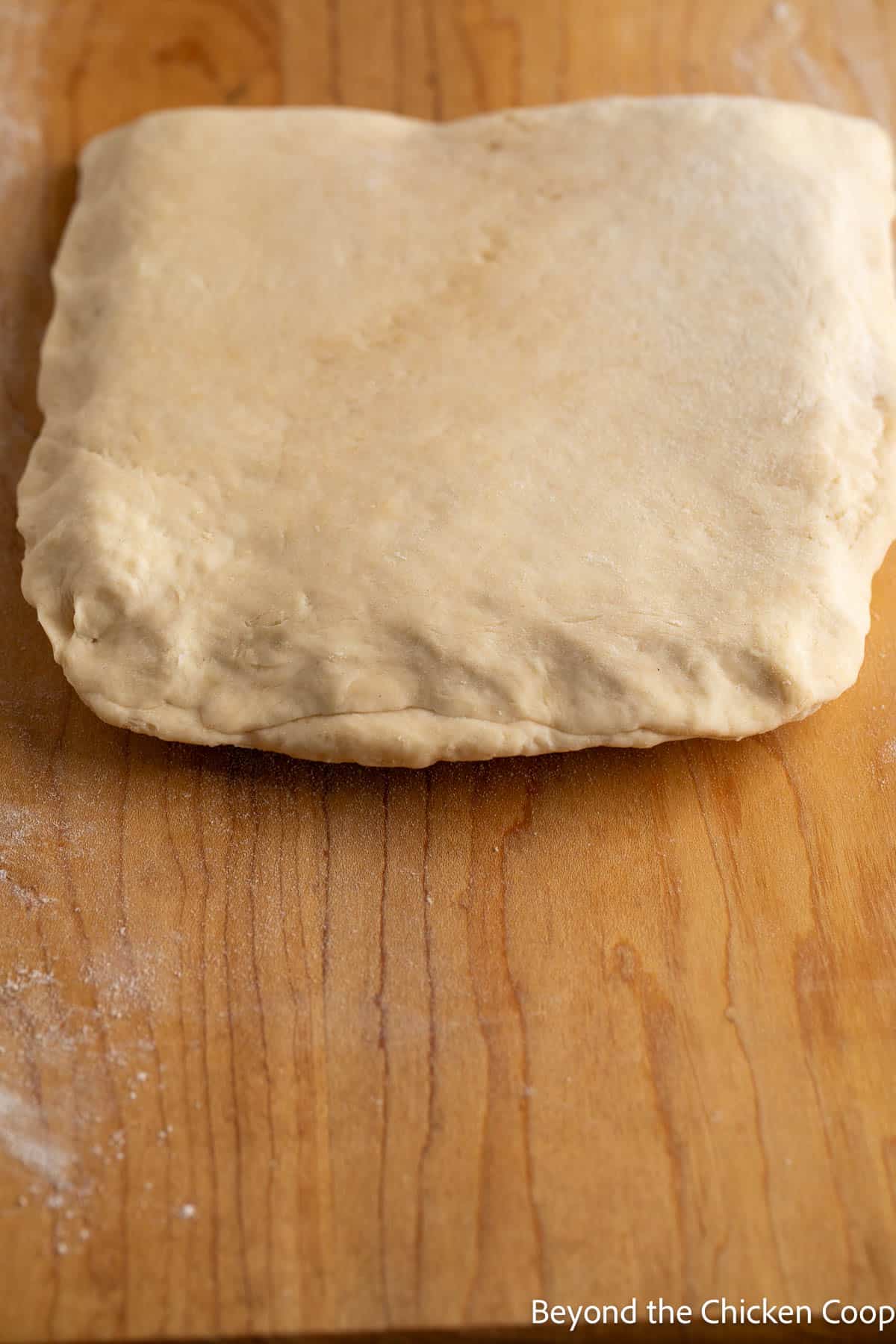 Sealing the butter packet between puff pastry dough. 