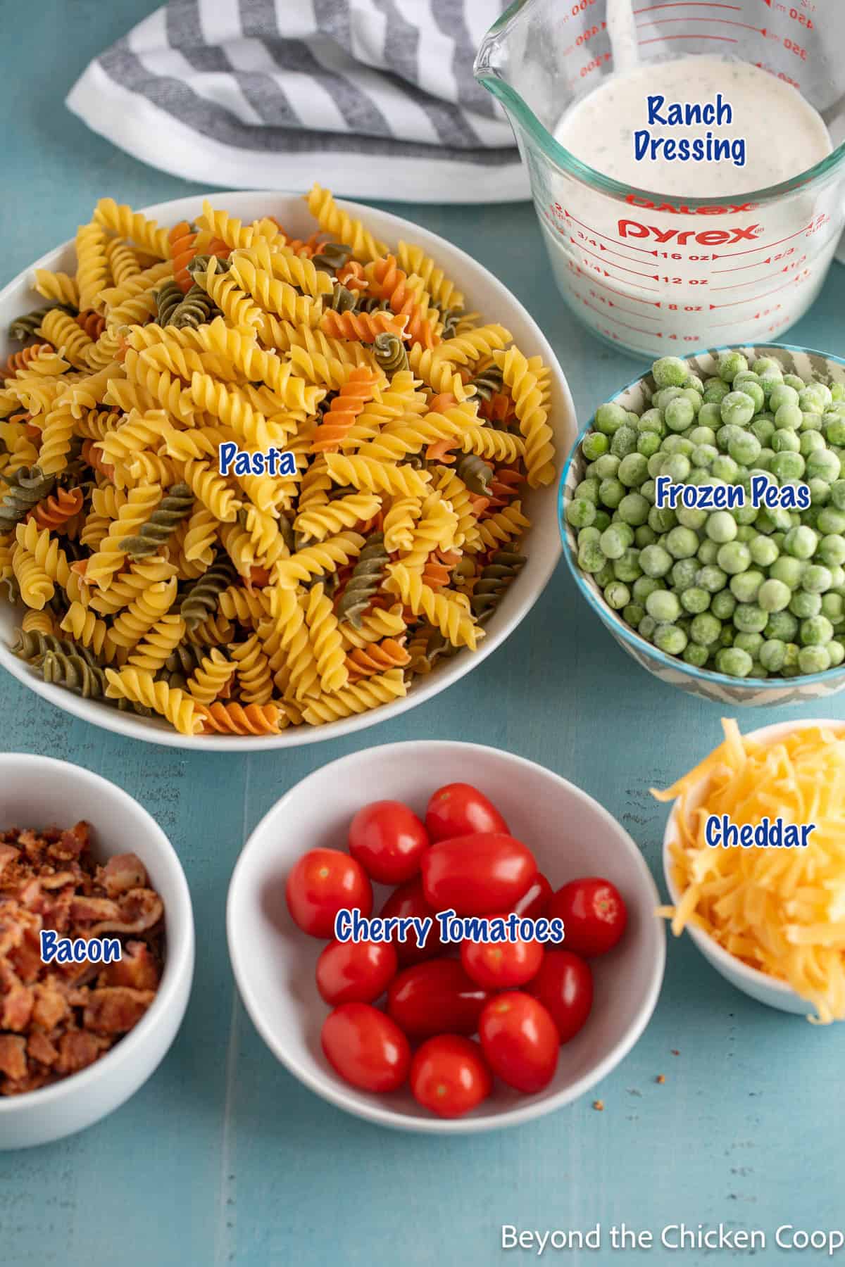 Pasta salad ingredients in small bowls. 