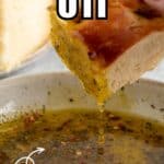Oil with herbs dripping from a slice of bread.