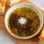 Bread Dipping Oil topped with Parmesan cheese in a bowl.