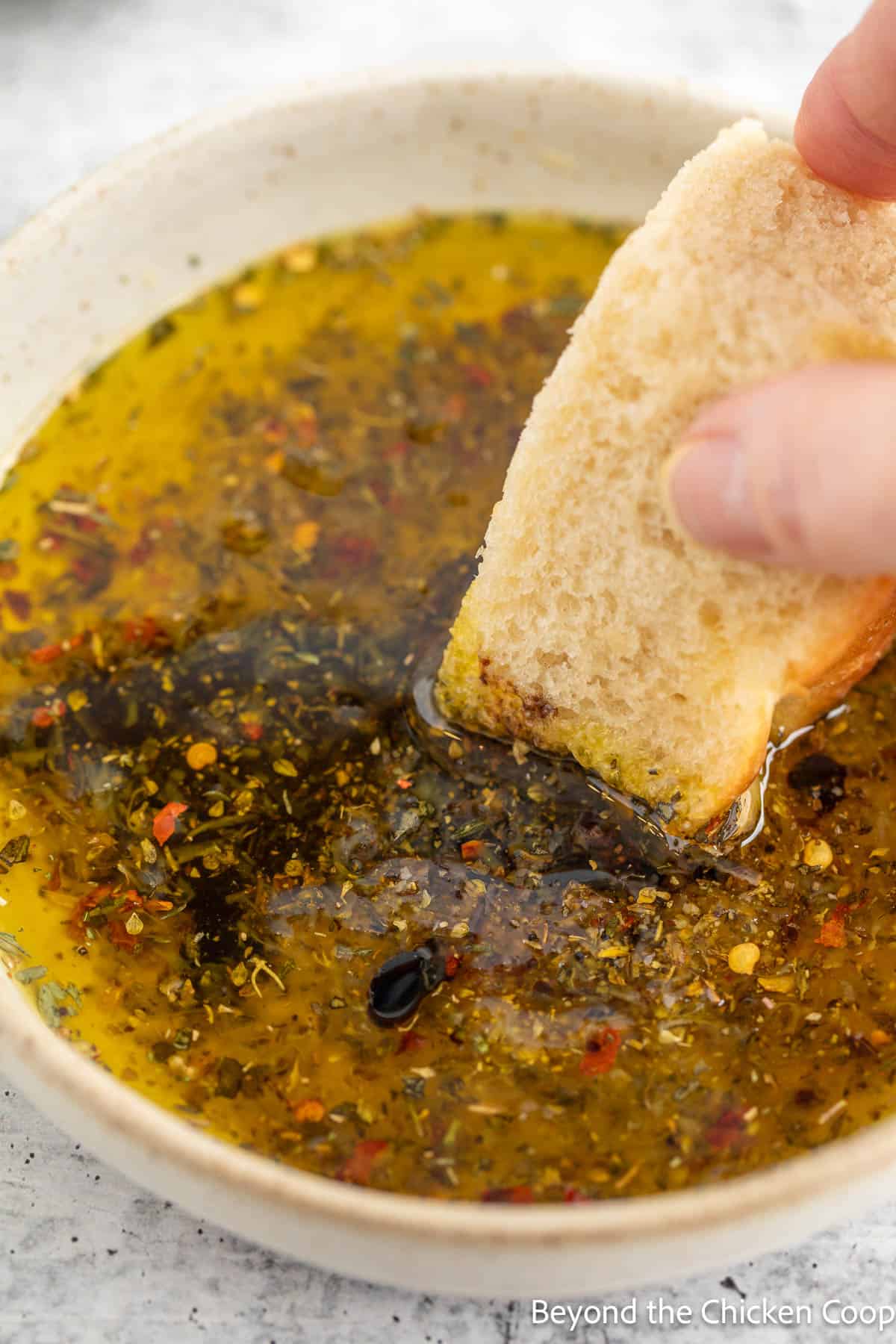 A piece of bread dunked into oil and balsamic. 
