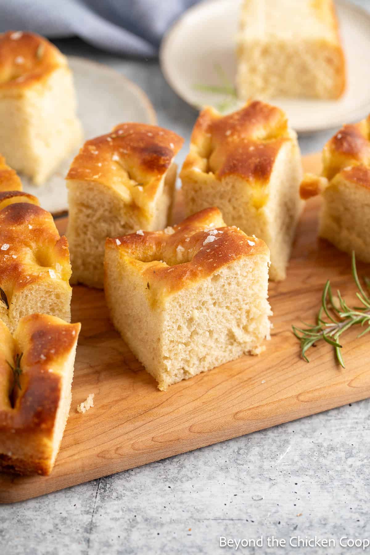 Slices of focaccia bread on a wooden board. 