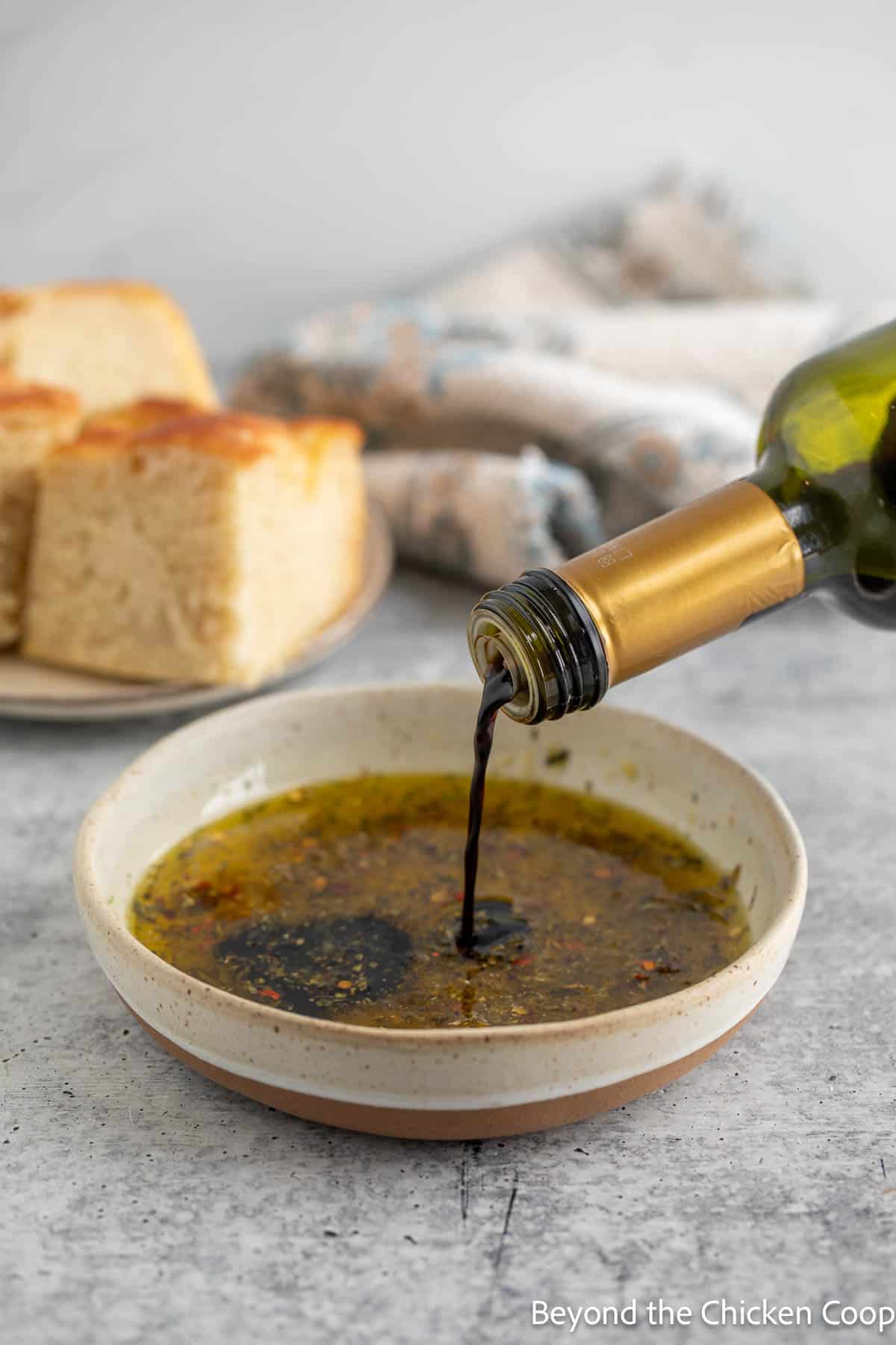 Pouring balsamic vinegar into olive oil. 