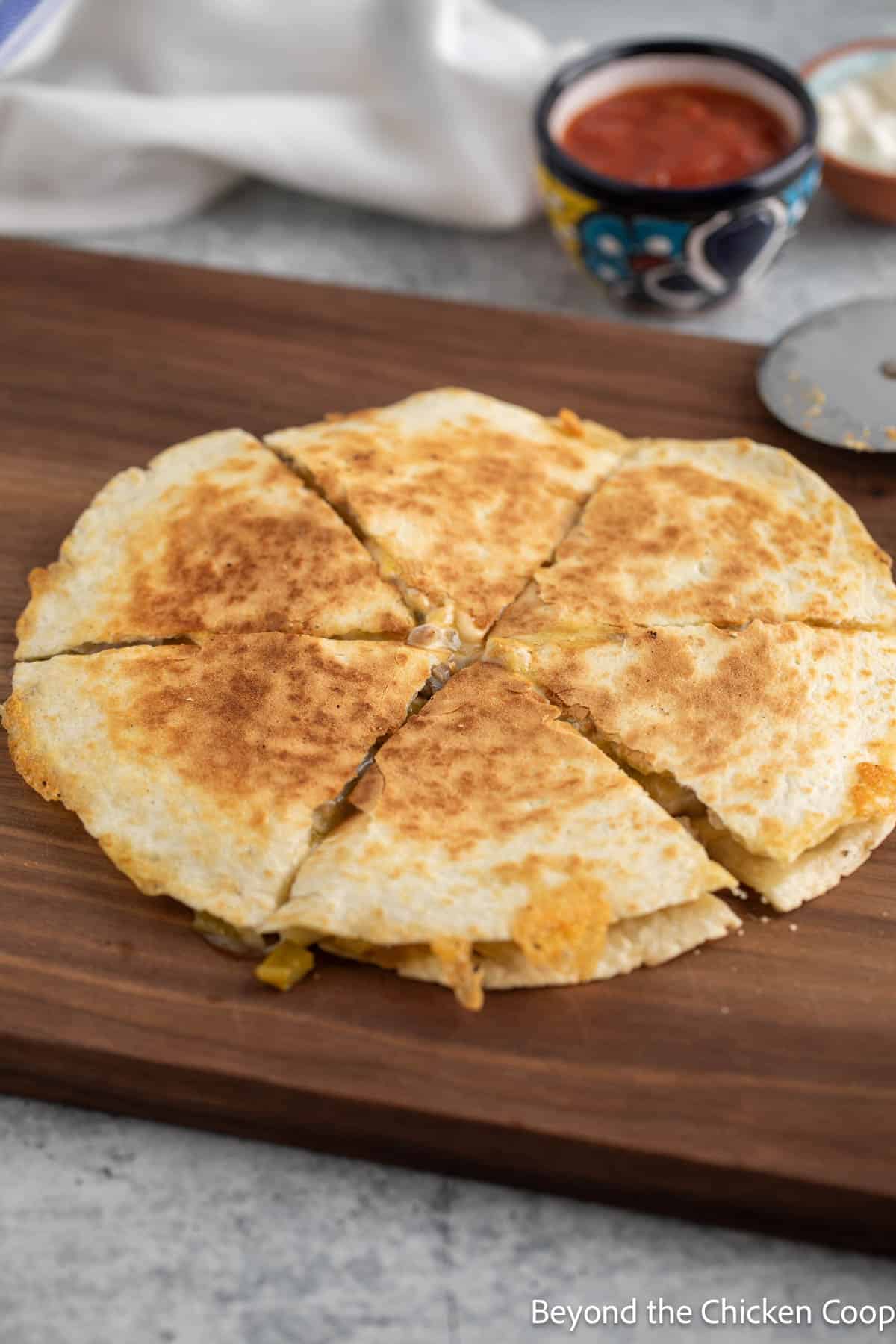 A cooked quesadilla on a cutting board. 