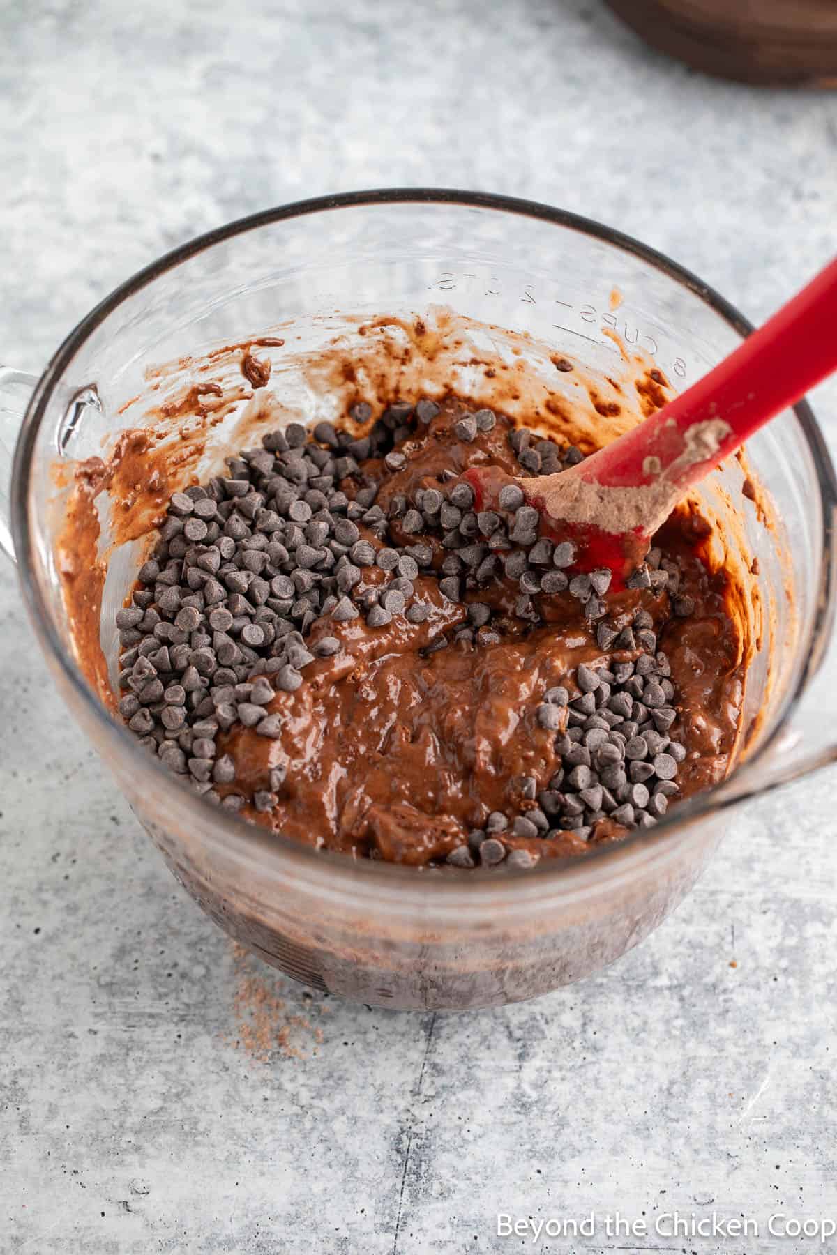 Folding chocolate chips into a chocolate batter. 