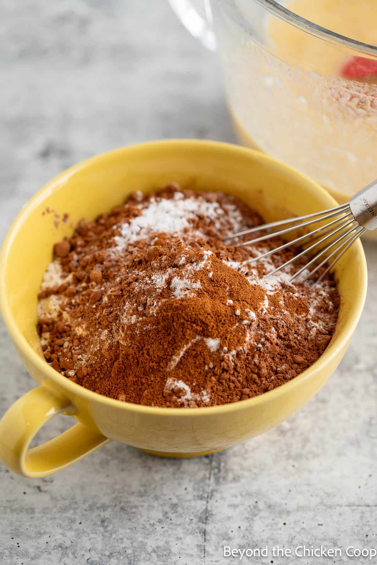 Flour and cocoa powder combined together in a yellow mug. 