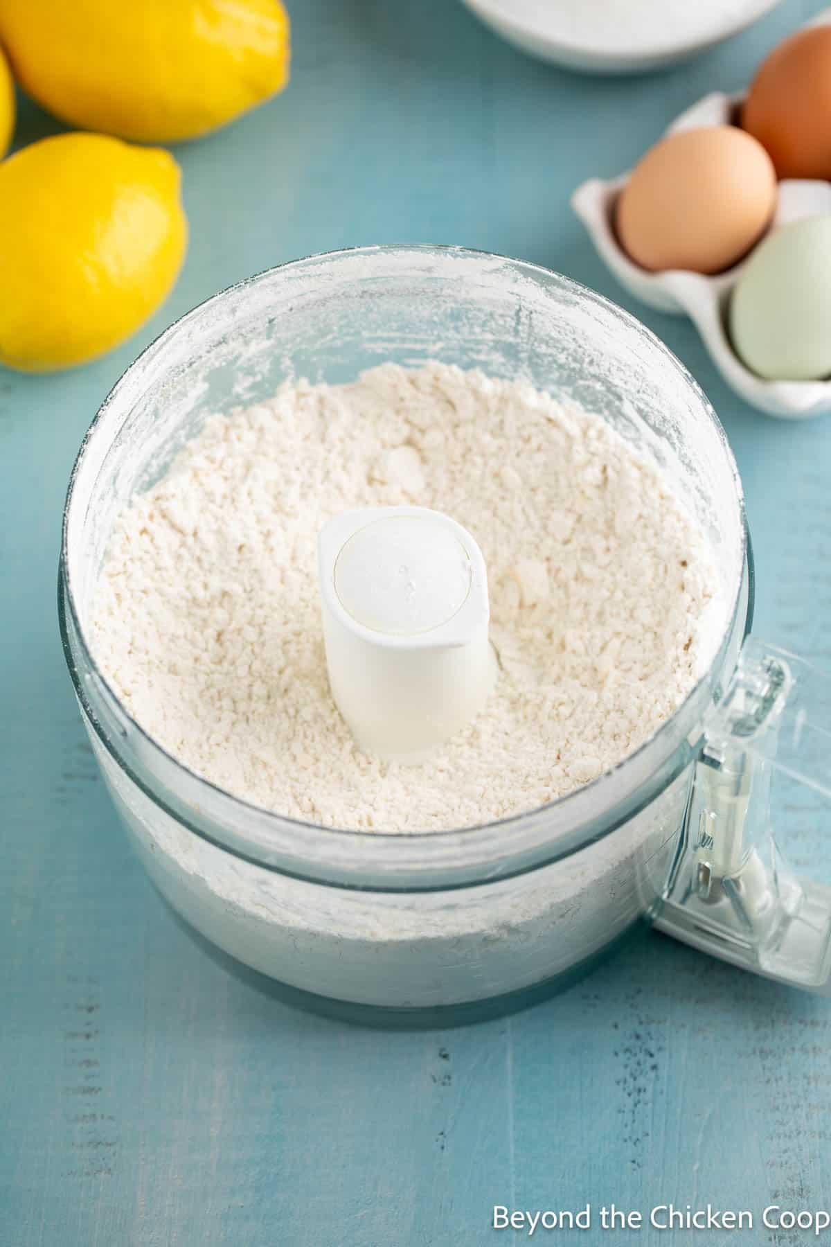 Mixed shortbread crust in a food processor bowl. 