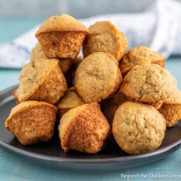 Mini Banana Muffins stacked on a black plate.