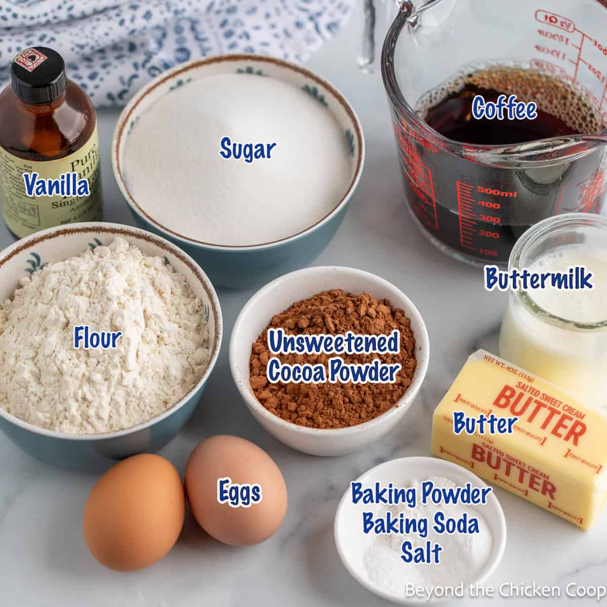 Small bowls filled with ingredients for making a chocolate cake. 