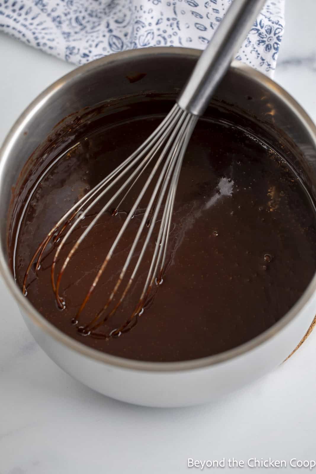 Whisking together chocolate frosting in a pan. 