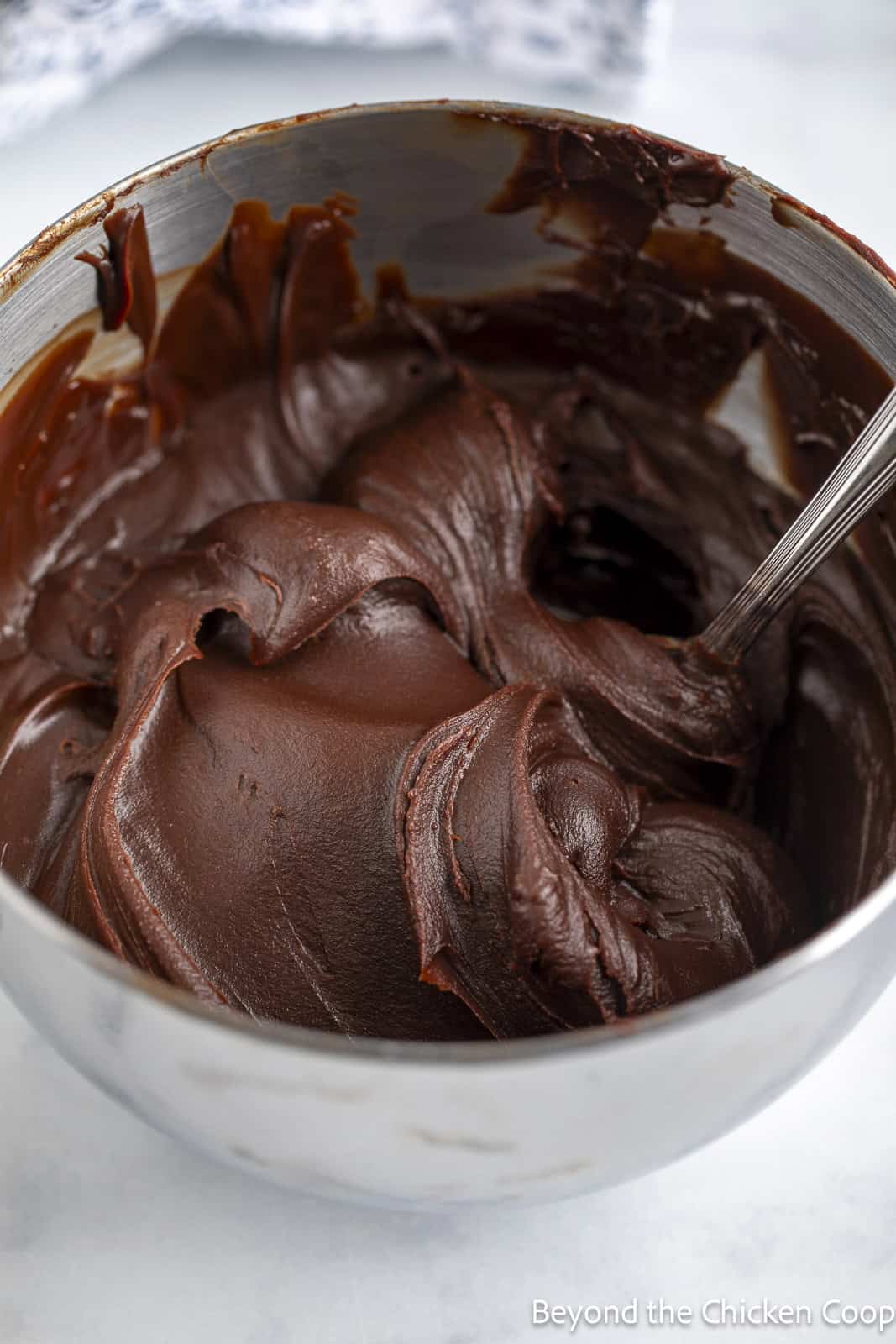 A bowl filled with creamy chocolate ganache frosting. 