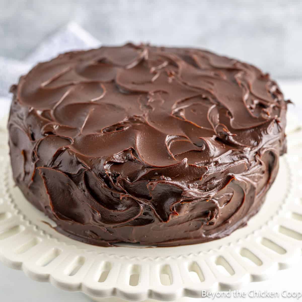 Chocolate Ganache with cocoa powder swirled on a layered cake. 