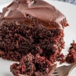 A slice of a two layer cake with chocolate frosting.