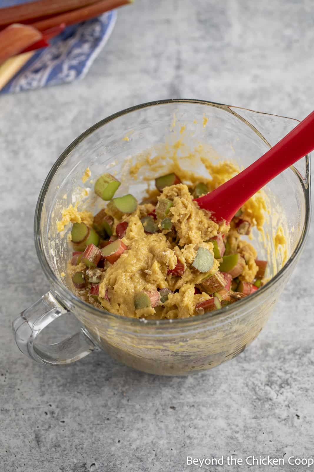 Mixing rhubarb into a batter. 