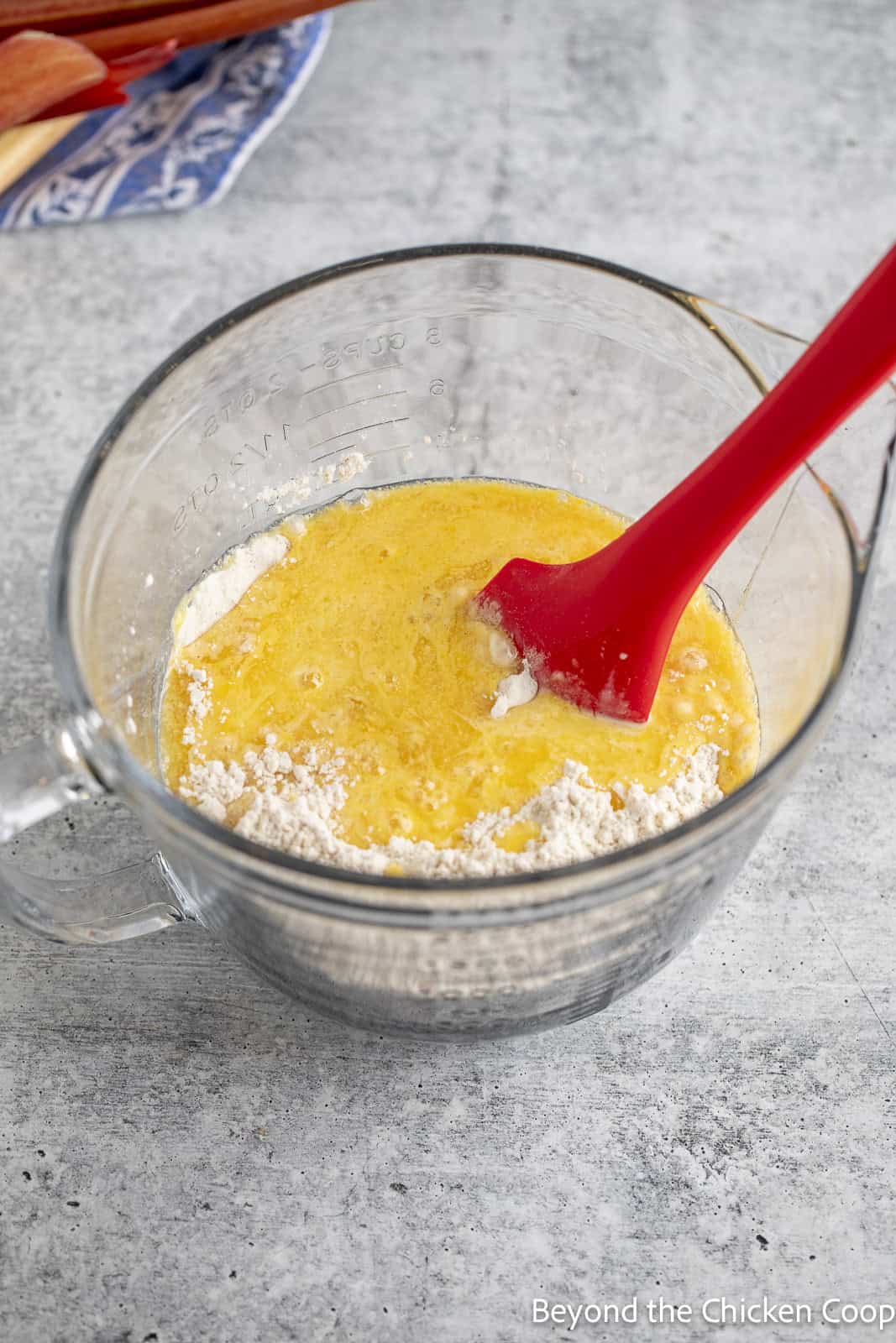 Mixing wet and dry ingredients together with a red spatula.